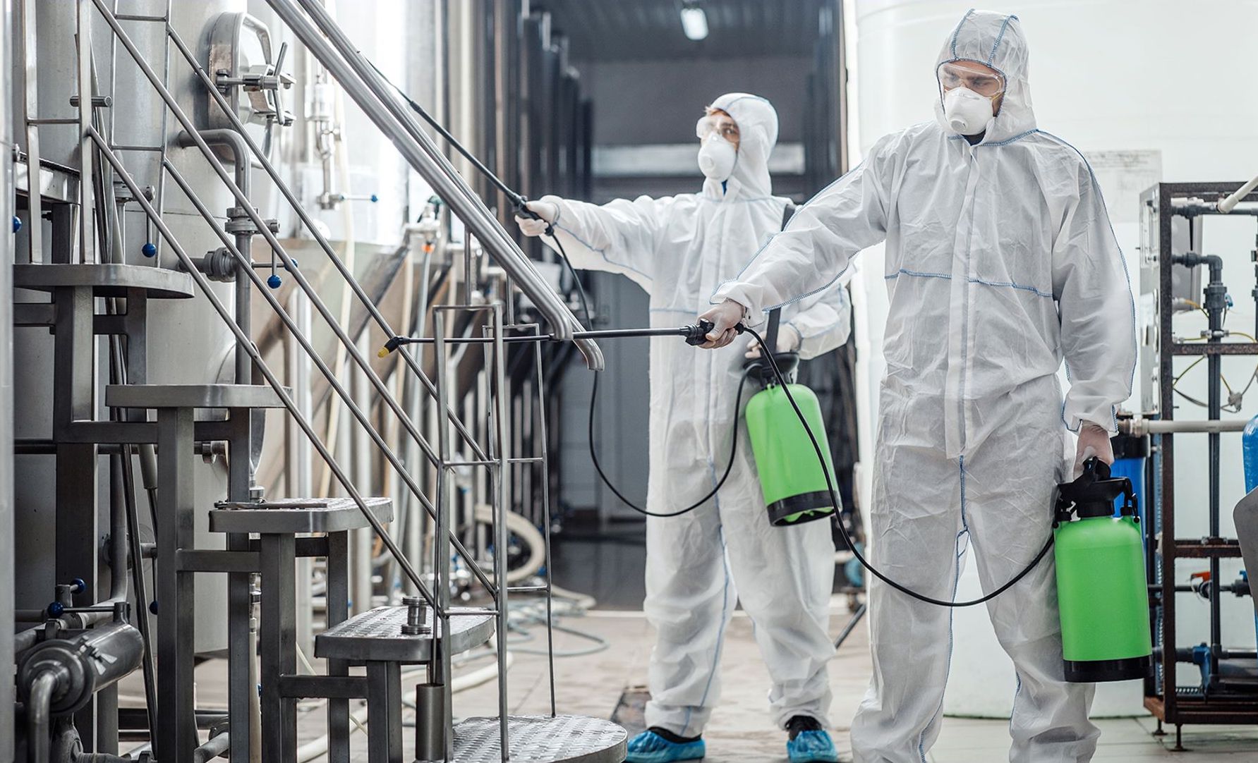 Personal con equipo de protección aplica un tratamiento en una instalación industrial; fotografía del servicio de sanitización publicada por TNI